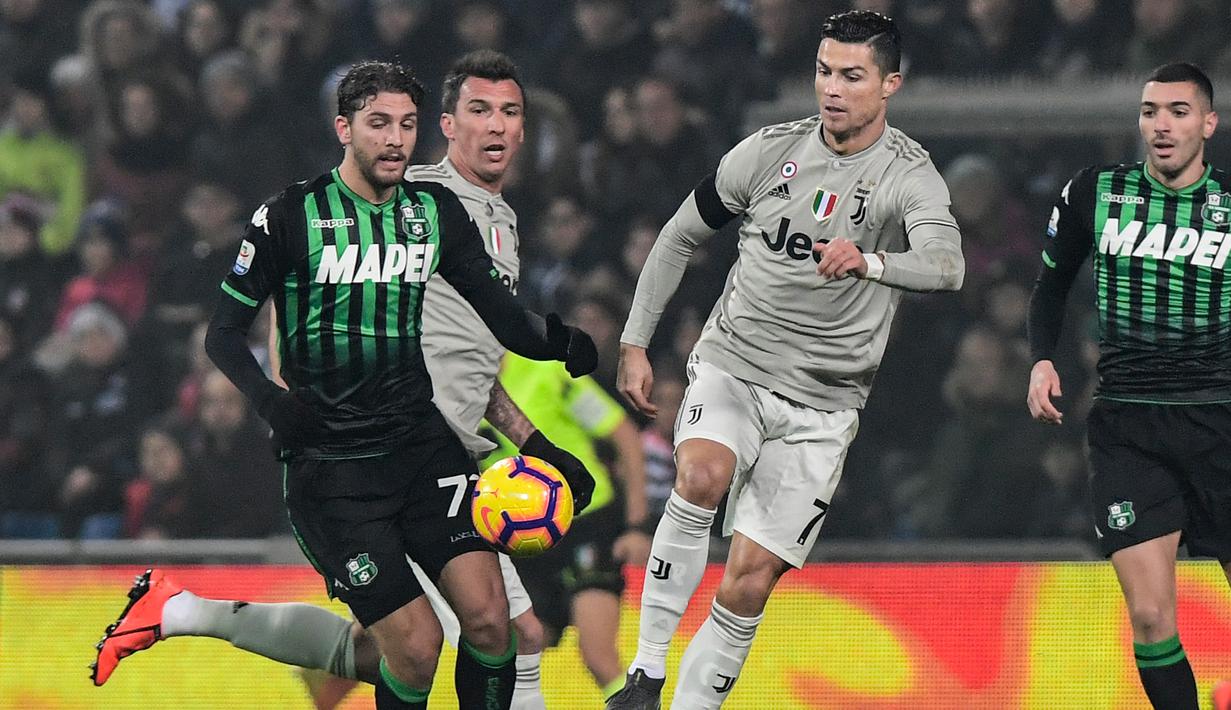 Aksi Cristiano Ronaldo melewati Manuel Locatelli pada laga lanjutan Serie A yang berlangsung di stadion Mapei, Reggio Emilia, Senin (11/2). Juventus menang 3-0 atas Sassuolo. (AFP/Miguel Medina)