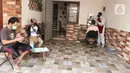 Tukang cukur mengenakan APD saat memotong rambut di halaman rumah pelanggan, Kelapa Dua, Depok, Jawa Barat, Senin (27/4/2020). Penerapan PSBB Kota Depok membuat tukang cukur tersebut menerima jasa panggilan ke rumah dan mengenakan APD untuk mencegah penularan COVID-19. (Liputan6.com/Herman Zakharia)
