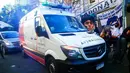 Mobil ambulans yang membawa Diego Maradona melintas di depan fans di La Plata, Argentina, Selasa (3/11/2020). Sejumlah fans Argentina berkumpul di depan rumah sakit untuk memberi dukungan kepada sang legenda. (AP/Natacha Pisarenko)