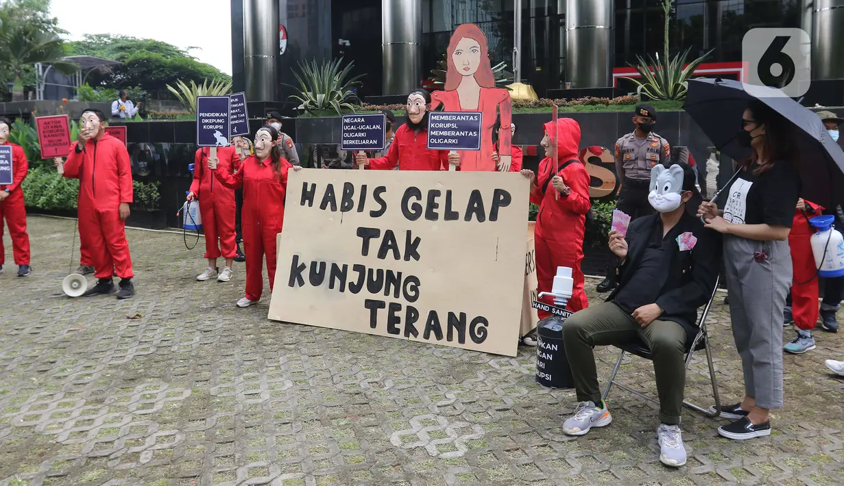 Sejumlah aktivis Indonesia Corruption Watch (ICW) dan Gerakan #BersihkanIndonesia melakukan aksi teatrikal saat unjuk rasa di depan Gedung KPK, Jakarta, Rabu (8/12/2021). Aksi dalam rangka memperingati Hari Anti Korupsi Sedunia pada 9 Desember 2021. (Liputan6.com/Herman Zakharia)