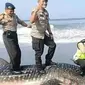 Polisi berfoto injak hiu paus. (Solopos.com/Twitter)