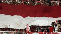 Suporter membentangkan bendera Merah Putih raksasajelang menyaksikan laga Timnas Indonesia U-19 melawan Jepang U-19 pada perempat final Piala AFC U-19 2018 di Stadion GBK, Jakarta, Minggu (28/10). Indonesia kalah 0-2. (Liputan6.com/Helmi Fithriansyah)