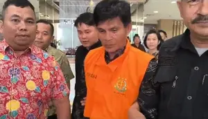 Tersangka korupsi jualan sawit milik pemerintah daerah Kabupaten Kuansing digiring petugas untuk dibawa ke penjara. (Liputan6.com/M Syukur)