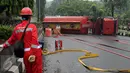 Petugas pemadam api dari Pertamina melihat kondisi truk tangki BBM yang terbalik di ruas Jalan Tegar Beriman Kabupaten Bogor, Jumat (15/4/2016). Menurut warga, truk tangki terbalik sekitar pukul 05.00 dini hari. (Liputan6.com/Helmi Fithriansyah)