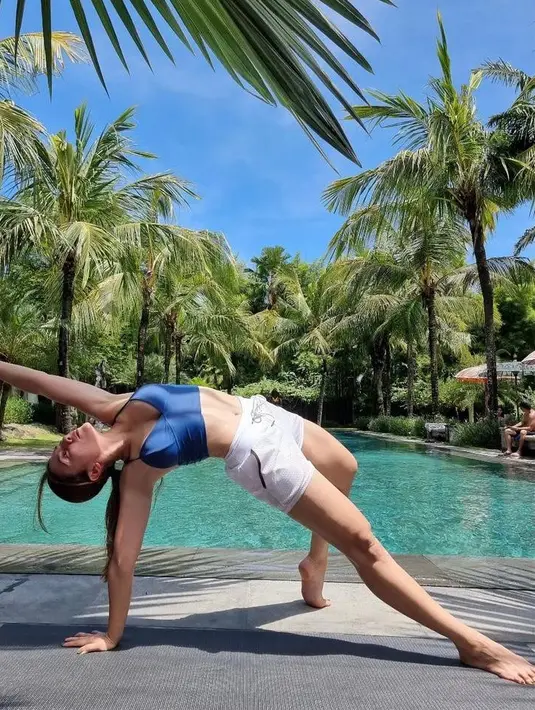 Saat Yoga, Wulan Guritno tampil chic kenakan crop top dan short pants sambil pamerkan tubuh fleksibel. (Instagram/wulanguritno).