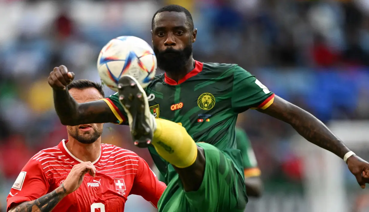Bek Kamerun, Nicolas Nkoulou mengontrol bola di depan striker Swiss pada laga Grup G putaran final Piala Dunia Qatar 2023 di Al-Janoub Stadium, Al-Wakrah, Doha (24/11/2022). Nicolas Nkolou tampil di Premier League Liga Inggris bersama watford hanya satu musim pada 2021/2022. Jarang dimainkan, ia hanya tampil dalam 3 laga di Premier League Liga Inggris. (AFP/Kirill Kudryavtsev)