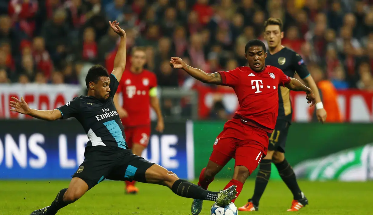  Pemain Arsenal Francis Coquelin berebut bola dengan pemain Bayern Munich Douglas Costa pada lanjutan Liga Champion di Allianz Arena, Munich, Jerman, Kamis (5/11/15) dini hari. Bayern menang 5-1. (Reuters / Michael Dalder)