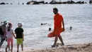 Seorang penjaga pantai berjalan di sebuah pantai di Coney Island, New York City, Amerika Serikat, pada 1 Juli 2020. Pada Rabu (1/7), delapan pantai di New York City secara resmi dibuka untuk berenang selama jam kerja harian penjaga pantai, yakni mulai pukul 10.00 hingga 18.00. (Xinhua/Wang Ying)