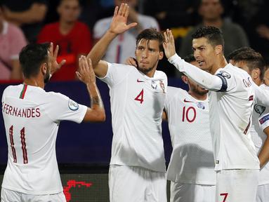 Para pemain Portugal merayakan gol yang dicetak Cristiano Ronaldo ke gawang Serbia pada laga Kualifikasi Piala Eropa 2020 di Belgrade, Sabtu (7/9). Serbia kalah 2-4 dari Portugal. (AFP/Pedja Milosavljevic)