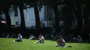 Seorang wanita membaca buku di bawah sinar matahari di Victoria Tower Gardens dekat Gedung Parlemen di London (23/7/2019). Suhu melonjak di atas 30C (86F) di Inggris pada 23 Juli dengan para peramal cuaca memperkirakan suhu setinggi 37C (96.8F) sebelum akhir pekan. (AFP Photo/Ben Stansall)