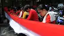 Sejumlah warga tampak serius menjahit bendera merah putih saat mengikuti lomba di Kelurahan Pekojan, Jakarta, Minggu (16/8/2015). Sebanyak 700 ibu-ibu mengikuti lomba menjahit bendera Merah Putih sepanjang 500 meter. (Liputan6.com/Panji Diksana)