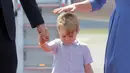 Ekspresi Pangeran George setibanya di bandara Tegel bersama orang tuanya, Pangeran William dan Kate Middleton serta sang adik Putri Charlotte di Berlin, Rabu (19/7). George kelihatan lelah dan mengantuk saat turun pesawat. (Kay Nietfeld / dpa via AP )