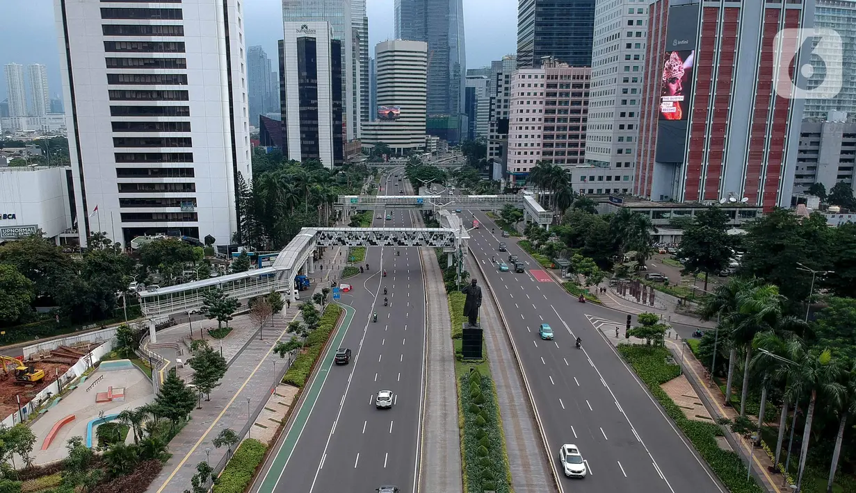Foto aerial kendaraan melintas di Jalan Jenderal Sudirman, Jakarta, Selasa (24/3/2020). Sejumlah ruas jalan utama ibu kota lebih lengang dibandingkan hari biasa karena sebagian perusahaan telah menerapkan bekerja dari rumah guna menekan penyebaran COVID-19. (Liputan6.com/Faizal Fanani)