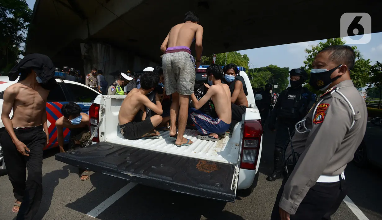 Sejumlah orang menaiki mobil polisi setelah diamankan di Kawasan Senayan, Jakarta, Kamis (8/10/2020). Mereka diduga hendak melakukan unjuk rasa di depan gedung DPR. (merdeka.com/Imam Buhori)