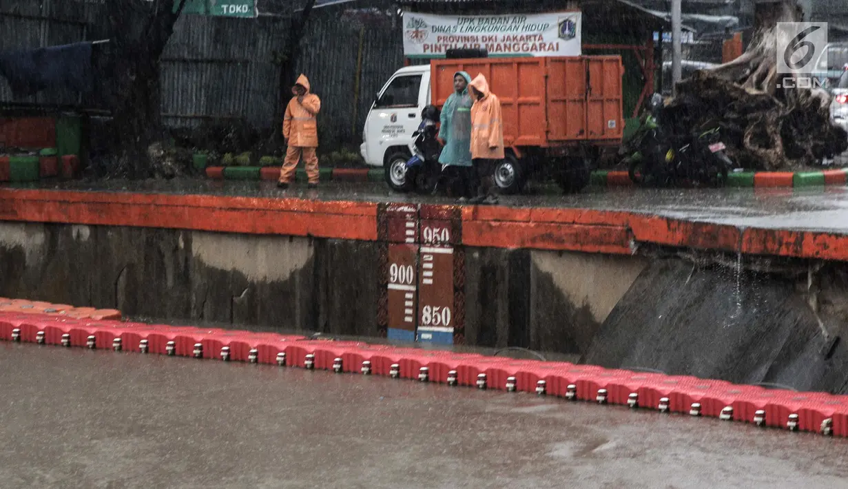 Sejumlah petugas memeriksa ketinggian air Pintu Air Manggarai, Jakarta, Senin (5/2). Warga di sekitaran Sungai Ciliwung diimbau untuk terus waspada akan tingginya limpahan air. (Liputan6.com/Faizal Fanani)