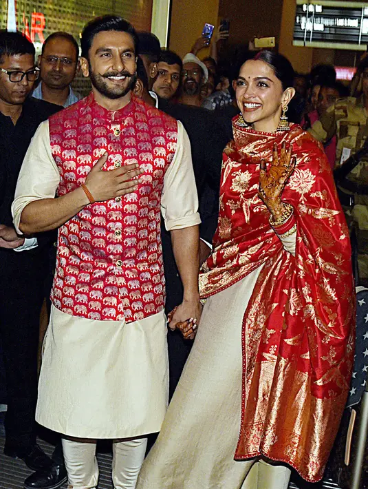 Pasangan bintang Bollywood India, Ranveer Singh dan Deepika Padukone menyapa penggemar yang menyambut mereka di bandara Mumbai, Minggu (18/11). Setelah pacaran selama 5 tahun, Deepika dan Ranveer akhirnya resmi melangsungkan pernikahan di Italia. (AFP)