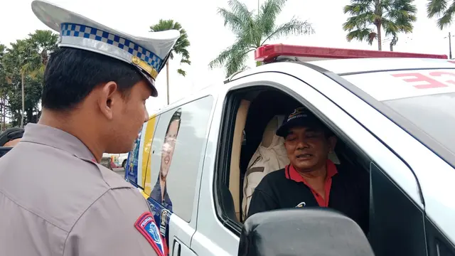 Petugas Satuan Lalu Lintas Polres Bogor menindak satu unit mobil ambulans lantaran melawan arus di jalur Puncak, Bogor, Jumat (23/12/2022) pagi. (Liputan6.com/Achmad Sudarno)