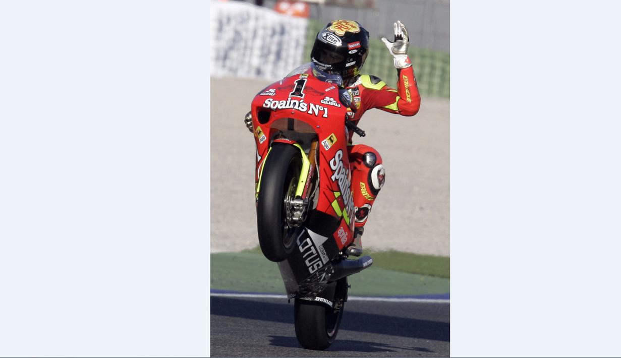 Juara dunia 250cc, Jorge Lorenzo, mengangkat roda depan motornya saat kualifikasi GP Valencia, (3/11/2007). (AFP Photo/Diego Tuson)