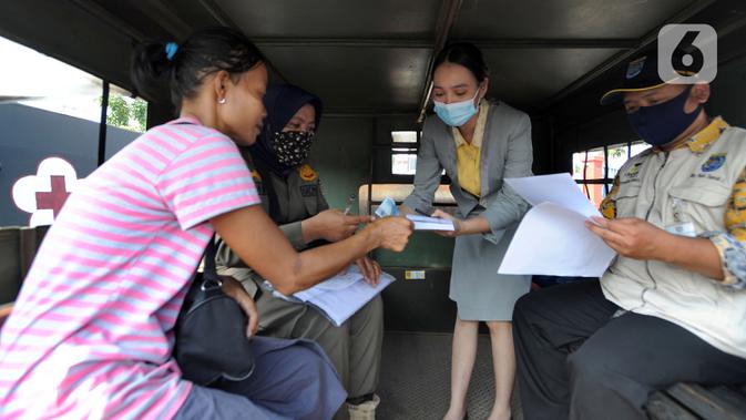 Petugas melakukan denda terhadap warga yang tidak mengenakan masker di kawasan Jalan Ir. H. Juanda, Depok, Jawa Barat, Kamis (23/7/2020). Sejumlah pengendara dan penumpang angkutan umum terjaring razia Gugus Tugas Percepatan Penanganan COVID-19 Kota Depok. (merdeka.com/Arie Basuki)