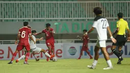 Pemain Timnas Indonesia U-17 Muhammad Nabil Asyura berebut bola dengan Timnas Guam U-17  dalam laga Kualifikasi Piala Asia U-17 2023 Grup B di Stadion Pakansari, Cibinong, Kabupaten Bogor, Jawa Barat, Senin (3/10/2022). Tim besutan Bima Sakti Tukiman itu menghajar Guam 14-0 pada laga pertama. (FOTO: Dok. PSSI)