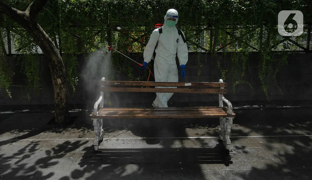 Petugas PMI DKI Jakarta menyemprot disinfektan pada bangku di trotoar kawasan Bundaran HI, Senin (7/2/2022). Penyemprotan disinfektan itu untuk sterilisasi di beberapa titik guna mencegah penyebaran COVID-19 varian omicron yang saat ini sedang mengalami peningkatan. (Liputan6.com/Herman Zakharia)
