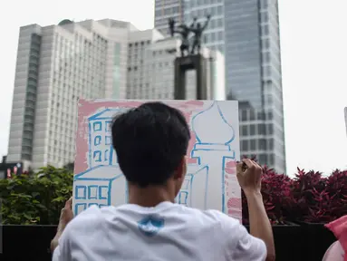 Seorang pengunjung mengikuti aksi melukis di kanvas disela kegiatan Car free Day (CFD) di kawasan Bundaran HI, Jakarta, Minggu (12/2). Aksi yang digelar oleh Greenpeace itu untuk mengenalkan masyarakat tentang sadar polusi. (Liputan6.com/Faizal Fanani)