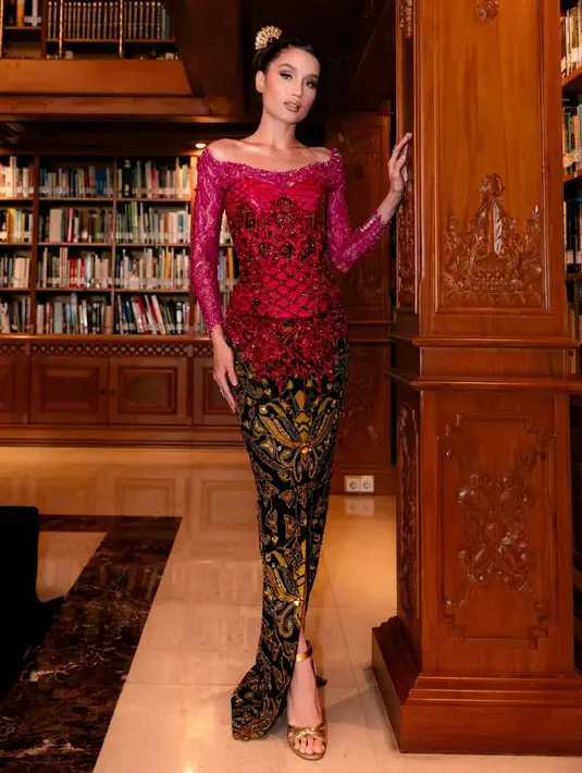 Kain batik berwarna hitam dengan motif emas dan merah memberikan kesan megah sekaligus modern. Belahan di bagian depan kain memberikan sentuhan kontemporer tanpa menghilangkan kesan sopan dan tradisional. Sentuhan akhir berupa sandal heels emas memperpanjang siluet kaki dan menyempurnakan keseluruhan tampilan. [@philipekarunia].