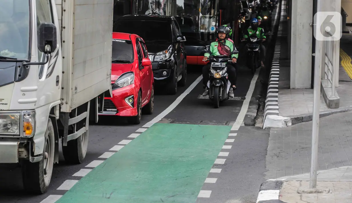 Sejumlah kendaraan roda dua melintas di jalur sepeda di Cipete Raya, Jakarta, Jumat (22/11/2019). Walaupun kendaraan yang melewati jalur sepeda akan dikenai sanksi denda Rp500.000, masih banyak pengendara yang masih bandel melintas dikarenakan kepadatan arus lalu lintas. (Liputan6.com/Faizal Fanani)
