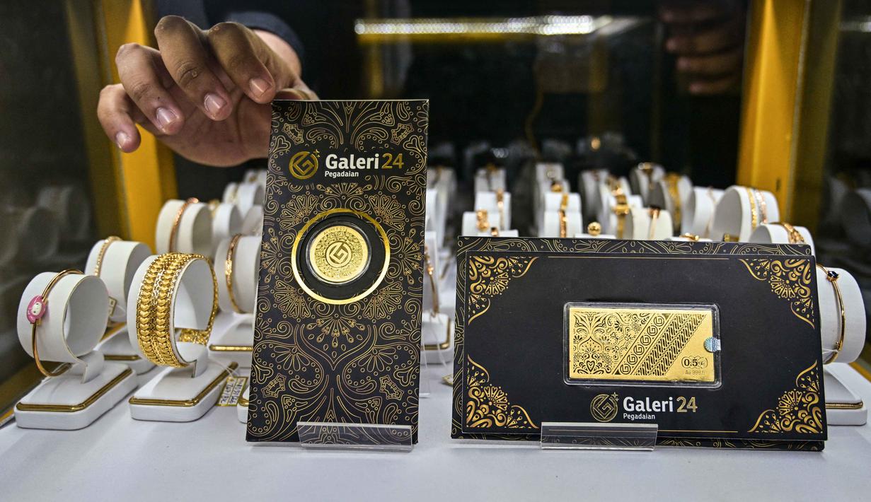 Salah satu karyawan memperlihatkan lembaran emas yang dipajang di Galeri 24, Surabaya, Jawa Timur, pada Kamis 16 Oktober 2025. (Juni KRISWANTO/AFP)