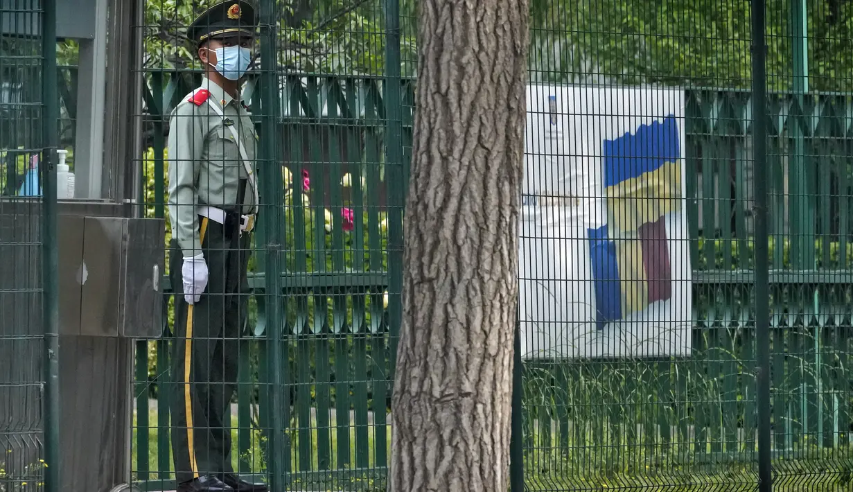 Seorang polisi paramiliter berjaga di dekat papan reklame yang menunjukkan dukungan untuk Ukraina yang dipajang di sela-sela pagar Kedutaan Besar Rumania di Beijing, Rabu (17/5/2023). (AP Photo/Andy Wong)