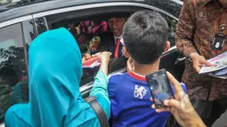 Presiden Joko Widodo (Jokowi) saat membagikan buku kepada kerumunan warga di Jalan Cicendo, Bandung, Jumat (24/4/2015). (Liputan6.com/Faizal Fanani)