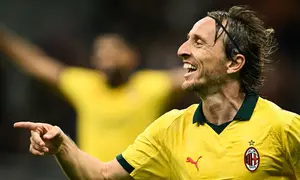 Pemain AC Milan, Luka Modric, merayakan gol yang dicetaknya ke gawang Bologna pada pekan 3 Liga Italia Serie A di Stadion San Siro, Senin (15/9/2025) dini hari WIB. (Stefano RELLANDINI / AFP)