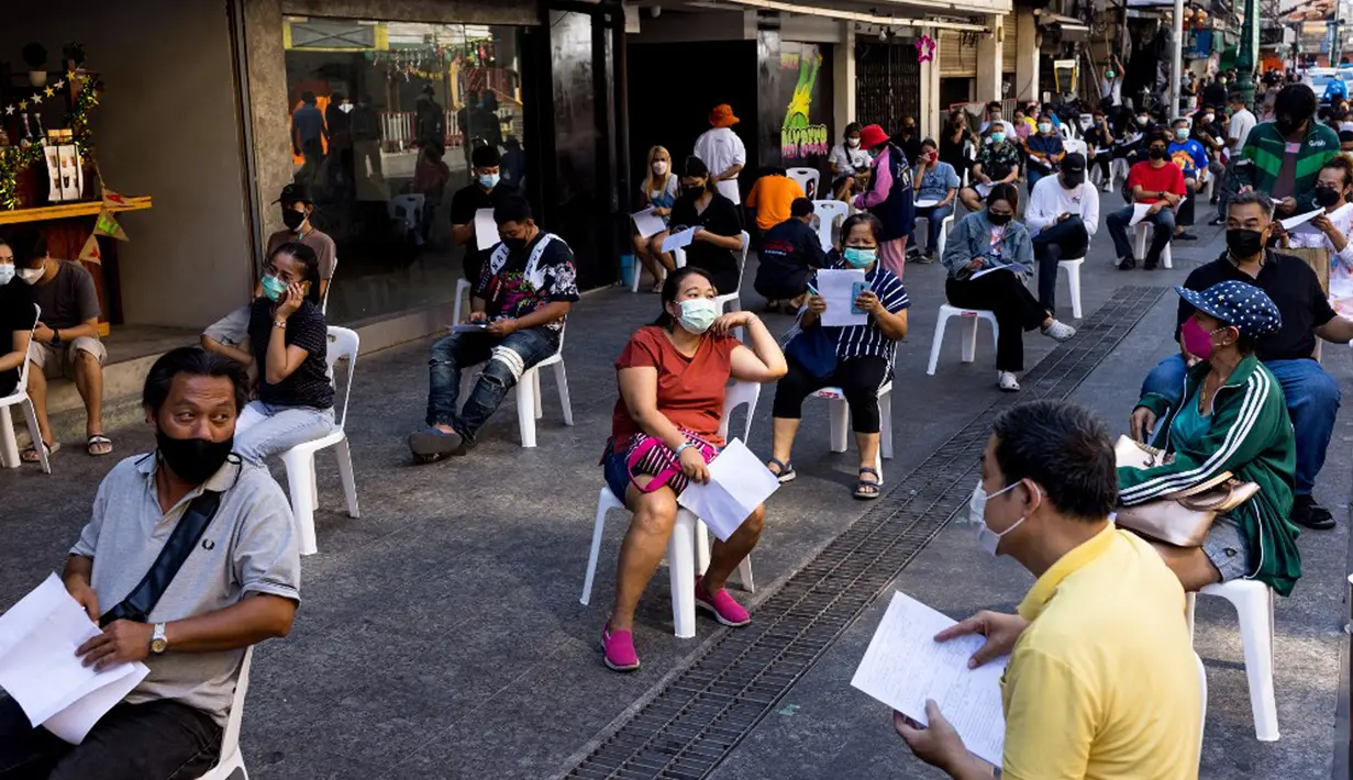 Pekerja perhotelan dan pariwisata mengantre untuk tes virus corona COVID-19 di Jalan Khao San, Bangkok, Thailand, Kamis (6/1/2022). (Jack TAYLOR/AFP)