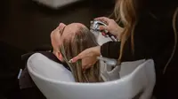 Ilustrasi wanita sedang melakukan hair treatment. Photo by Lindsay Cash on Unsplash