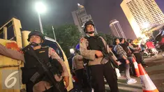 Petugas kepolisian bersenjata lengkap berjaga di kawasan Bundaran HI, Jakarta, Sabtu (31/12). Untuk mengamankan jalannya perayaan malam tahun baru, Polda Metro Jaya menempatkan personelnya di sejumlah sudut Ibu Kota. (Liputan6.com/Immanuel Antonius)