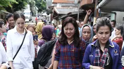 Cathy Sharon bersama Heppy Farida melitasi genangan air saat meninjau lokasi banjir di Pancoran, Jakarta, Selasa (21/02). Selain meninjau lokasi Cathy Sharon dan Heppy Farida juga memberikan bantuan untuk warga setempat. (Liputan6.com/Herman Zakharia)