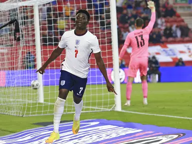 Pemain Inggris Bukayo Saka melakukan selebrasi usai mencetak gol ke gawang Austria pada pertandingan persahabatan di Stadion Riverside, Middlesbrough, Inggris, Rabu (2/6/2021). Inggris mengalahkan Austria dengan skor 1-0. (Lindsey Parnaby, Pool via AP)