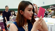 Seorang wanita merias diri saat mengikuti sebuah acara perjodohan di Hangzhou, Provinsi Zhejiang, China (14/5). Para Pria dan wanita mengikuti acara ini dengan harapan mendapatkan pasangan yang sesuai dengan kriterianya. (AFP Photo/Str/China Out)