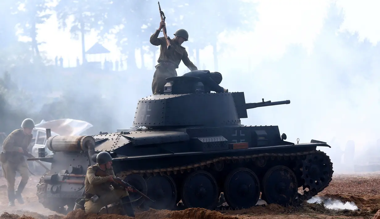 Para aktor memainkan sebuah adegan yang menceritakan tentara merebut tank musuh saat pertunjukan rekonstruksi pertempuran Perang Dunia II, di Memorial "Stalin Line", dekat Desa Goroshki, Belarusia, (10/9). (Reuters/Vasily Fedosenko)