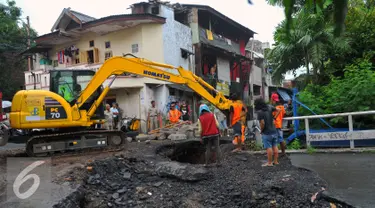 Petugas Dinas PU melakukan perbaikan Jembatan Inspeksi Kali Grogol yang ambles di Komplek Hankam, Slipi, Jakarta, Senin (21/3). Penyebab Amblesnya jembatan diduga terjadi pergeseran tanah dibagian pondasi jembatan. (Liputan6.com/Faisal R Syam)