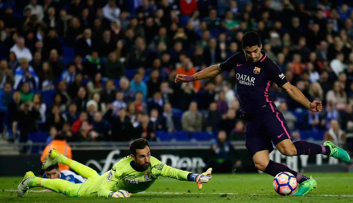 Luis Suarez saat mengecoh kiper Espanyol dalam laga Liga Spanyol, di Stadion RCDE, Spanyol, Sabtu (29/4). Menang 3-0 membawa Barca kembali ke puncak klasemen dan menjaga tekanan untuk Real Madrid. (AP Photo/ Manu Fernandez)