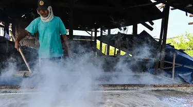 Seorang petani mengolah garam dengan cara tradisional di sebuah tambak di Lamnga, pinggiran Banda Aceh, Aceh, Selasa (7/3/2023). Petani di Aceh masih mengandalkan pola produksi tradisional, yakni sistem rebus. (CHAIDEER MAHYUDDIN/AFP)