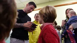Bintang Barcelona, Lionel Messi memberikan tanda tangan untuk pasien anak-anak saat melakukan kunjungan amal di Rumah Sakit Barcelona, Senin (4/1/2016). (AFP PHOTO / Lluis GENE)
