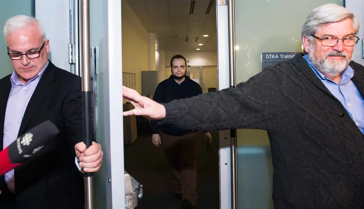 Joshua Boyle (tengah) tiba di bandara Toronto, Kanada (13/10). Pria asal Kanada ini disandera bersama istrinya Caitlin Coleman, dan ketiga anaknya oleh pasukan taliban di Afghanistan. (Nathan Denette / The Canadian Press via AP)