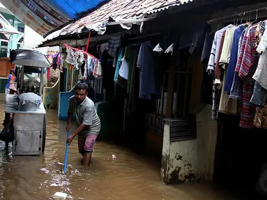 Aktivitas warga Kampung Pulo, Jakarta Timur, yang sejak Kamis (13/11/2014) subuh, rumah mereka terendam banjir. (Liputan6.com/Johan Tallo)