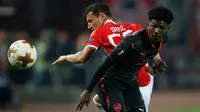 Pemain Arsenal, Ainsley Maitland-Niles berebut bola dengan pemain Red Star Belgrade, Slavoljub Srnic pada pertandingan Grup H Liga Europa di Stadion Rajko Mitic, Kamis (19/10). Arsenal menang 1-0, berkat gol Olivier Giroud. (AP/Darko Vojinovic)