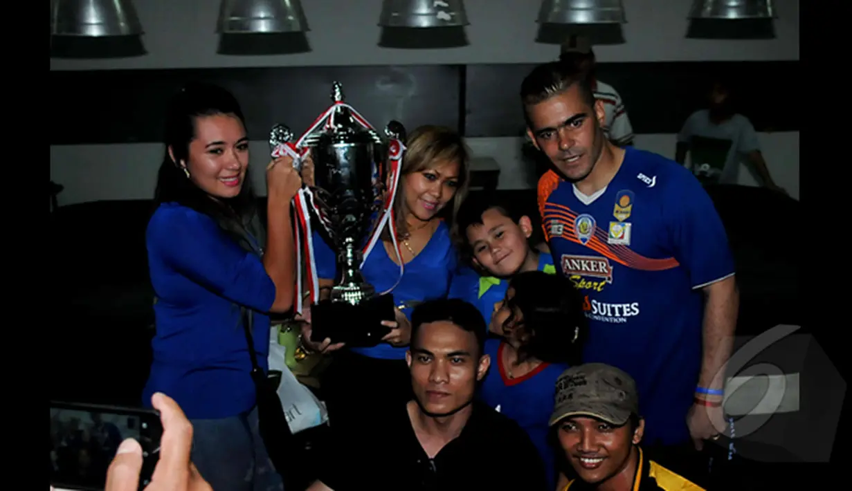 Penyerang Arema Cronus, Cristian Gonzales (kanan) berpose bersama keluarga sambil memegang piala SCM Cup di Stadion Jakabaring,Selasa (27/1/2015). Arema Cronus unggul 1-0 atas Sriwijaya FC. (Liputan6.com/Johan Tallo)