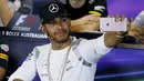 Pembalap F1 dari tim  Mercedes, Lewis Hamilton berselfie saat konferensi pers Formula One Grand Prix di Melbourne, Australia, (17/03/16). Pembalap asal Inggris ini merupakan salah satu pebalap yang eksis di media sosialnya. (REUTERS/Brandon Malone)