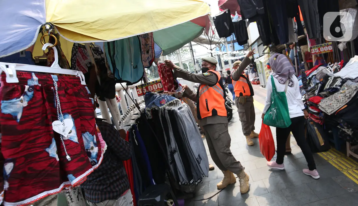 Petugas Satpol PP melakukan penertiban kepada pedagang kaki lima (PKL) yang bandel berjualan di trotoar Pasar Tanah Abang, Jakarta, Senin (4/10/2021). Penertiban dilakukan untuk memberikan kenyamanan dan keamanan bagi para pengguna jalan yang melintas di trotoar tersebut. (Liputan6.com/Angga Yuniar)