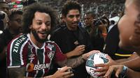 Marcelo memberikan tanda tangan ke penggemar saat perkenalan pemain baru Fluminense di Stadion Maracana, Rio de Janeiro, Brasil, Sabtu (11/03/2023) WIB. Mantan pemain Real Madrid tersebut bergabung hingga Desember 2024. (AFP/Carl De Souza)